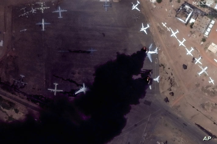 This satellite image provided by Maxar Technologies shows two burning planes at Khartoum International Airport, Sudan, Sunday…