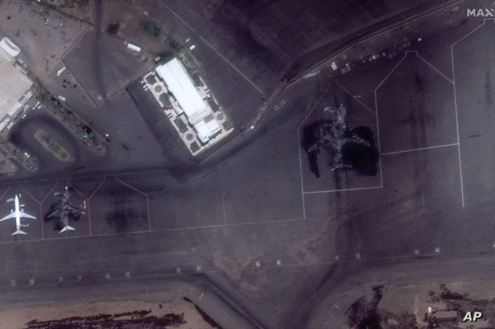 This satellite image provided by Maxar Technologies shows incinerated passenger planes at the Khartoum International Airport,…