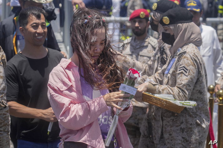 Chinese evacuees are welcomed by flowers as they arrive at Jeddah port, Saudi Arabia, Wednesday, May 3, 2023. Exhausted…